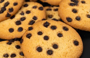 Siyah arkaplanda çikolata parçalı kurabiyeler