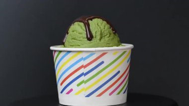 Siyah arka planda dondurmanın olduğu bir bardak.