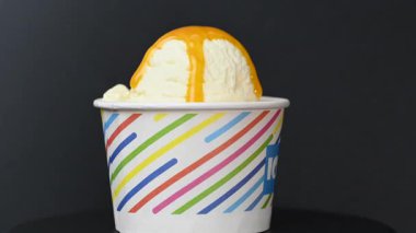 Siyah arka planda dondurmanın olduğu bir bardak.