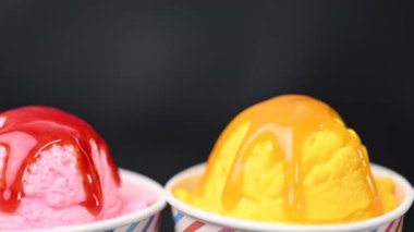 Siyah arka planda dondurmanın olduğu bir bardak.