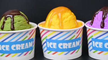 Siyah arka planda dondurmanın olduğu bir bardak.