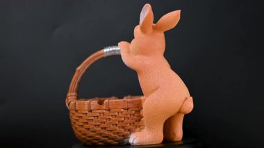 Siyah arka planda sepeti olan bir tavşan videosu.