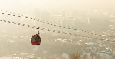 Kış dumanı sırasında kablolu araba. Sis sık sık Almaty 'de peyzaj kusurları nedeniyle oluşur. Kazakistan
