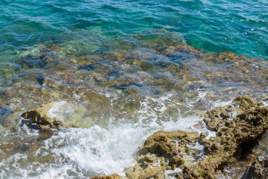 Sahilde mavi sularda kayalar