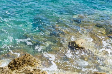 Sahilde mavi sularda kayalar