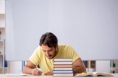 Sınıfta sınava hazırlanan genç bir öğrenci.