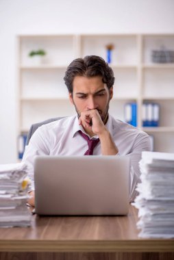 Genç işadamı ve ofiste çok fazla iş var.