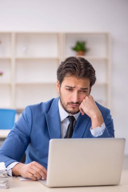 Genç işadamı ve ofiste çok fazla iş var.