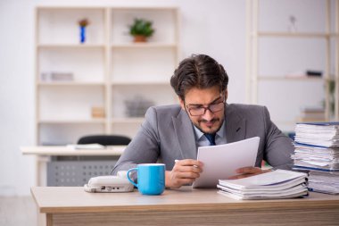 Genç işadamı ve ofiste çok fazla iş var.