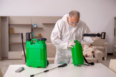 Yaşlı müteahhit evde haşere kontrolü yapıyor.