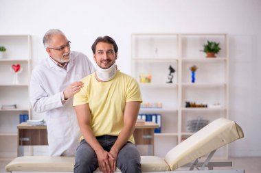 Genç boyun yaralı hasta yaşlı erkek doktoru ziyaret ediyor.