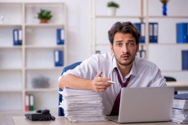 Genç işadamı ve işyerinde çok fazla iş var.