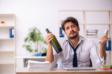 Erkek alkol bağımlısı çalışan ofiste oturuyor.
