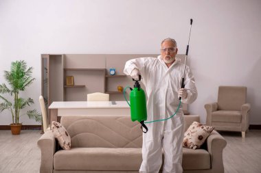 Yaşlı müteahhit evde haşere kontrolü yapıyor.