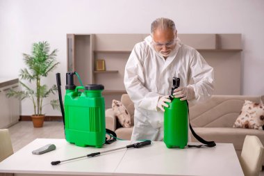 Yaşlı müteahhit evde haşere kontrolü yapıyor.