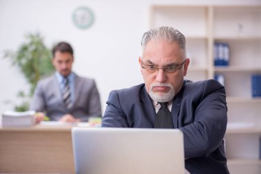 İki erkek çalışan işyerinde çalışıyor.