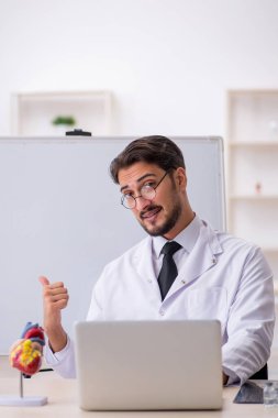 Genç doktor kardiyolog beyaz tahtanın önünde.