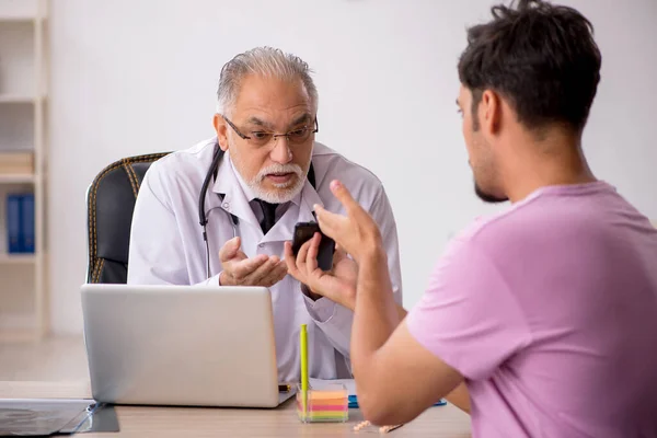Paciente Joven Visitando Viejo Médico Masculino — Foto de Stock