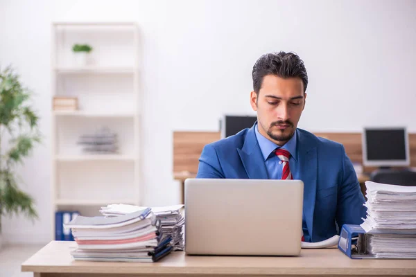 Young businessman employee unhappy with excessive work at workplace