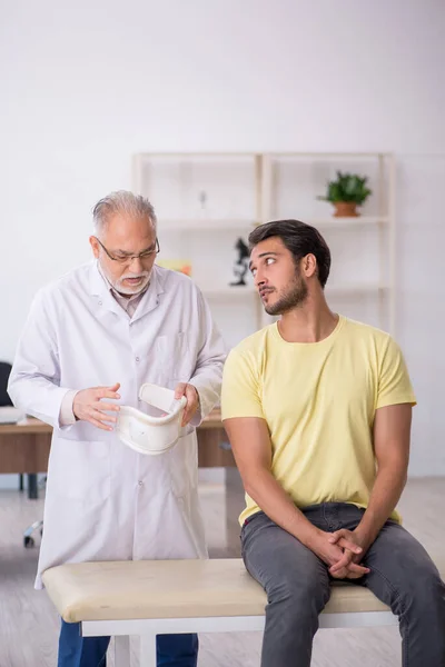 Cuello Joven Lesionado Paciente Visitando Viejo Médico Masculino —  Fotos de Stock