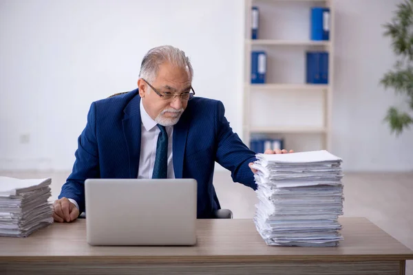 stock image Old businessman employee and too much work at workplace