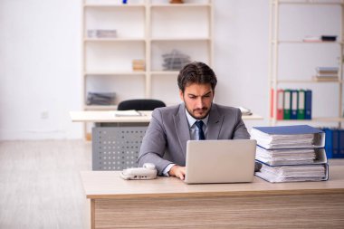 Genç işadamı ve ofiste çok fazla iş var.