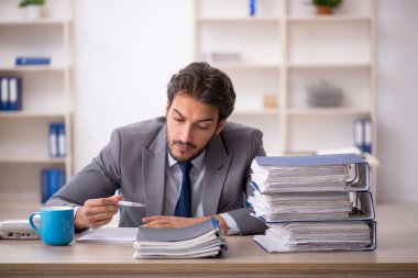 Genç işadamı ve ofiste çok fazla iş var.