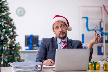 Genç çalışan Noel 'i ofiste kutluyor.