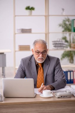 Eski işadamı teneffüste kahve içiyor.