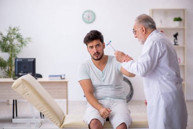 Genç hasta yaşlı erkek nörologu ziyaret ediyor.