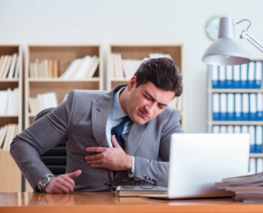 İşadamı ofiste acı hissediyor.