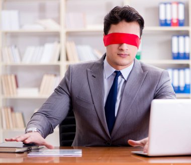 Ofiste masasında oturan gözü bağlı iş adamı.