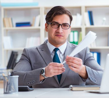 Ofisinde kağıt uçağı olan bir işadamı.