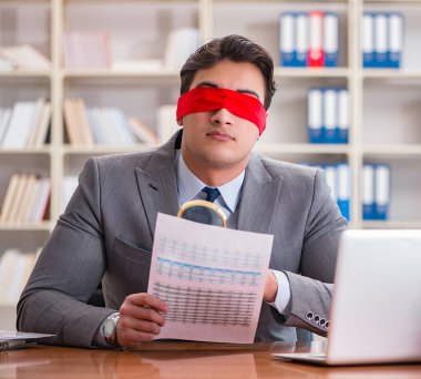 Ofiste masasında oturan gözü bağlı iş adamı.