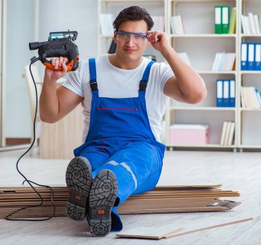 Zemin kaplamalarında çalışan genç işçi.