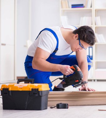 Zemin kaplamalarında çalışan genç işçi.