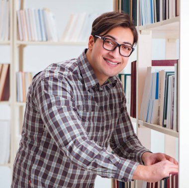 Üniversite kütüphanesinde kitap arayan genç öğrenci.