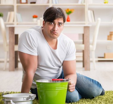 Komşu sel sızıntısıyla ilgilenen adam.