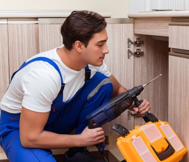 Mutfakta çalışan genç tamirci.