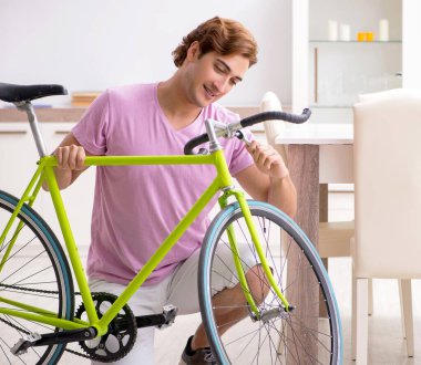 Kırık bisikletini tamir eden adam.