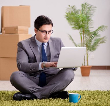 Ofisteki halının üzerinde oturan işadamı.