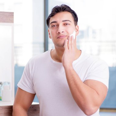 Genç yakışıklı adam sabahları tıraş oluyor.