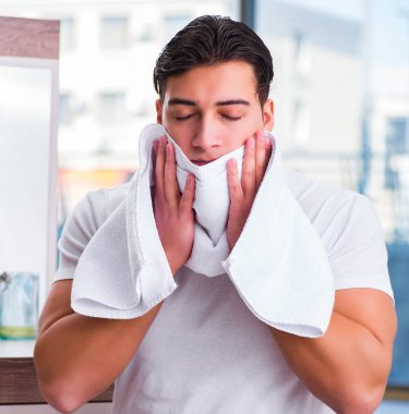 Yüz kremi süren genç yakışıklı adam.