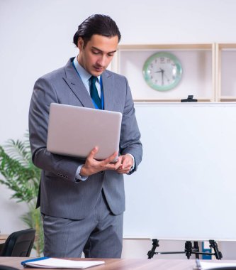 Beyaz tahtanın önünde duran genç iş adamı.