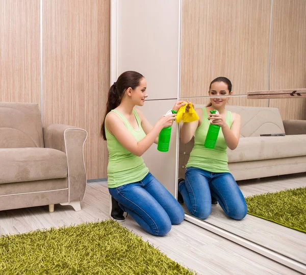家で鏡を掃除する若い女性 — ストック写真