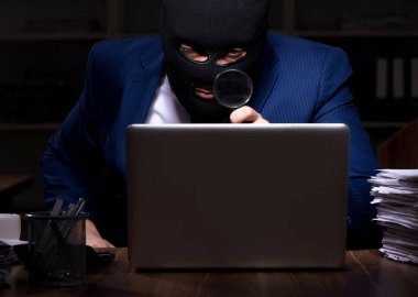 Erkek çalışan gece ofiste bilgi çalıyor.