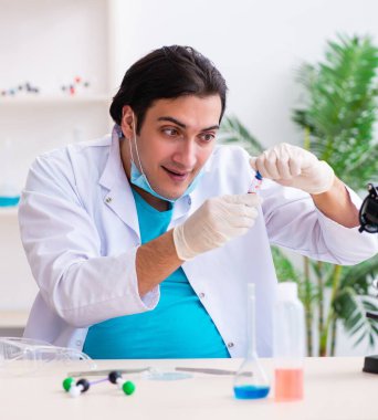 Laboratuvarda çalışan genç erkek kimyager.