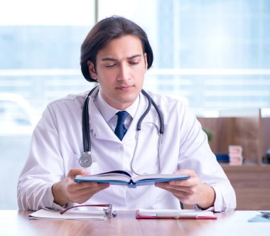 Klinikte çalışan yakışıklı genç doktor.