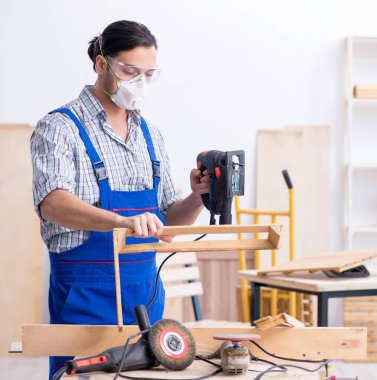 İçeride çalışan genç erkek marangoz.