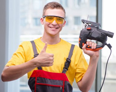 Sarı tulumlu genç inşaat işçisi.